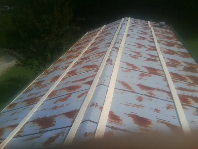 Rusted metal roof panels with new wood purlins before replacement — Storm Damage Roof Repair in Holbrook by Roofing Brothers